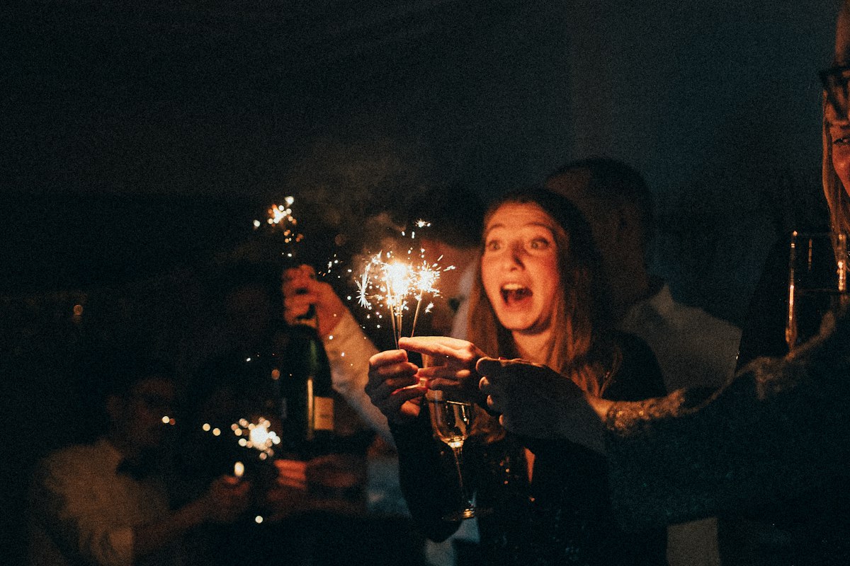Friends holding sparklers together at night