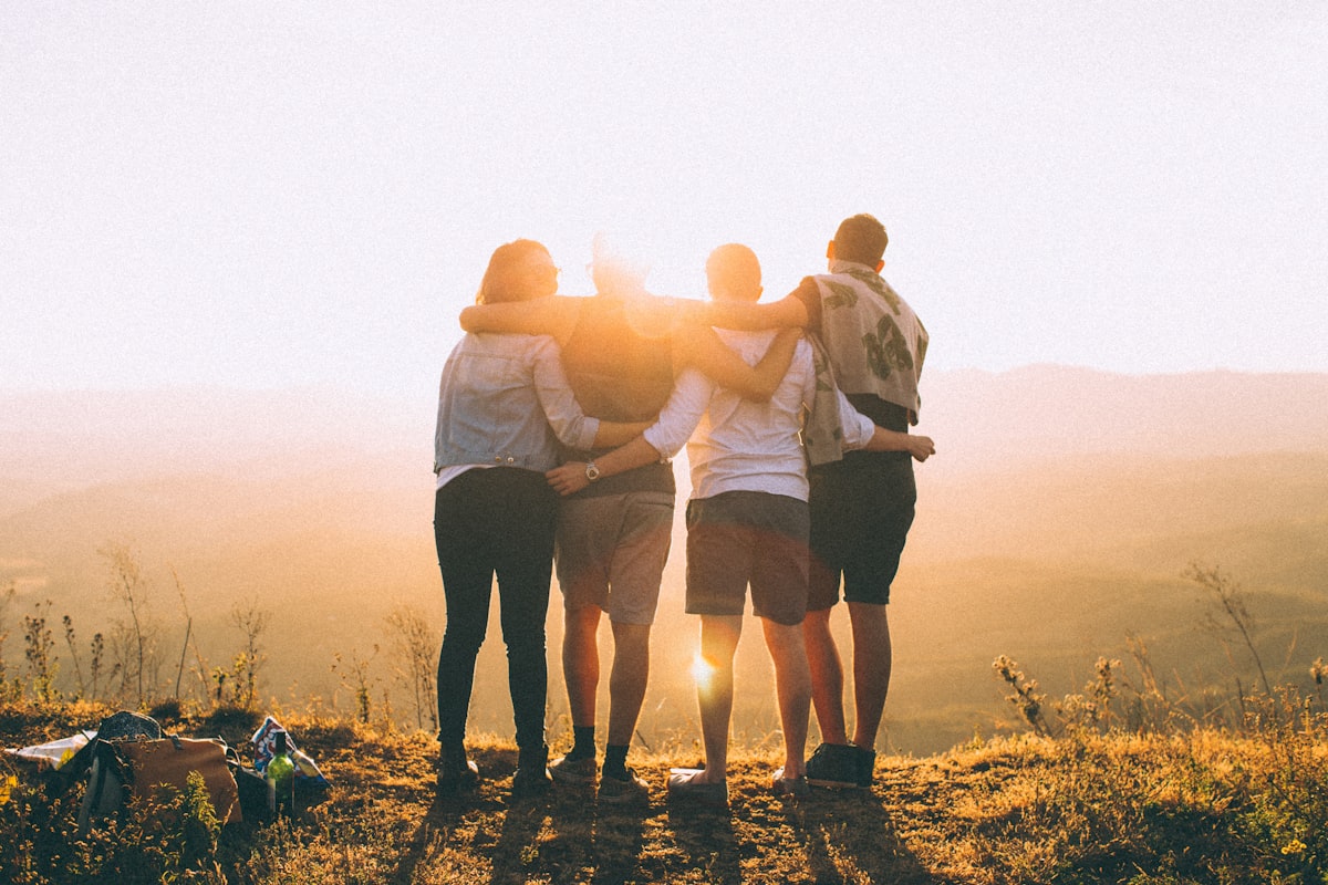 Sample postcard front: friends arm in arm watching a golden sunset